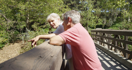 Mature white couple hanging out on a bridge