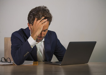 young sad and depressed business man working overwhelmed and frustrated on laptop computer office desk feeling upset and stressed suffering depression problem