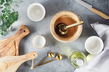 Wall Mural - Modern kitchen metal and wooden utensils on a table for cooking. Golden spoons, bowls and cutting boards. Top view.