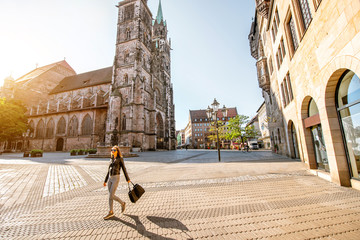 Wall Mural - Morning view on the saint Lorenz cathedral with woman walking in the old town of Nurnberg, Germany