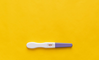 Pregnancy test on a yellow background. Close-up.