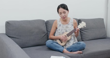 Canvas Print - Woman play a song with ukulele at home