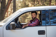 Bearded Driver Showing Thumb Up While Sitting In Pickup Truck In Forest