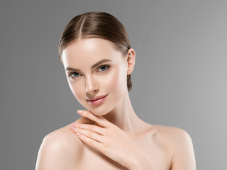 Wall Mural - beautiful woman face skin closeup portrait over gray background with healthy skin and hair