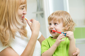 Canvas Print - Beautiful mother and kid son brushing teeth in bathroom