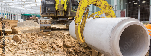 Photographie construction site excavator with a concrete pipe