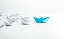 Leadership Concept With Blue Paper Ship Leading Among White On White Background.