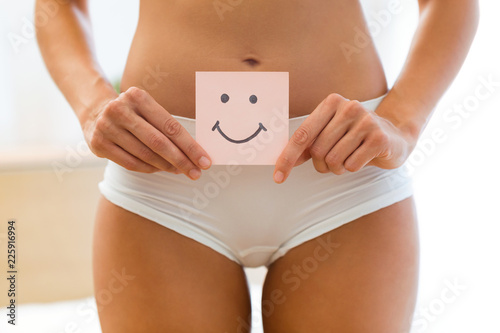 Fotomural Young woman holding paper with smile mark over her stomach