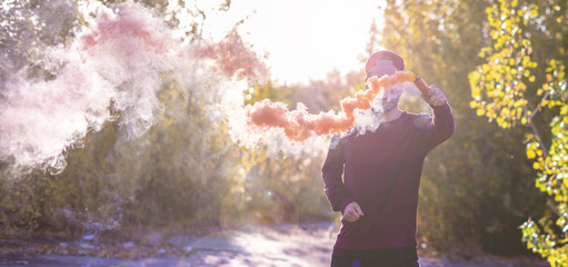 close up hand holding an orange smoke bomb, freedom happy and enjoy concept f