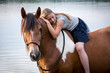 Mädchen und Pferd baden im See