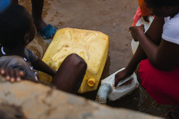 Wall Mural - people getting water at a well in Uganda, Africa