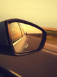 Reflection of sunny road at the car side mirrow. Rear view mirror reflection on sun down