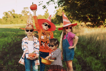 Halloween . Funny kids in with pumpkins in nature