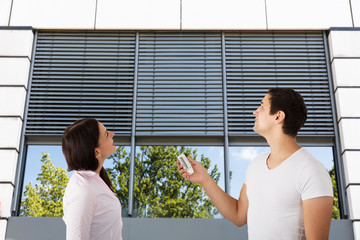 Wall Mural - Couple Adjusting Temperature Of Air Conditioner