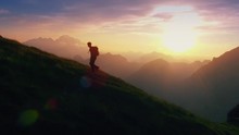 Aerial - Epic Shot Of A Man Hiking On The Edge Of The Mountain As A Silhouette In Colorful Sunset (edited)