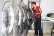 © simona - nice young brunette wash and clean some dresses and clothes at the laundry mat service automatic machine. Business activity for people with no much time and stress. city shop