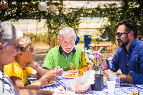 Plakat kaukaski rodziny obiad razem w słoneczny dzień zabawy i uśmiechnięty, podczas gdy jeść włoskie jedzenie makaronu. restauracja naturalne miejsce z taniego dania i rzeczy na stole
