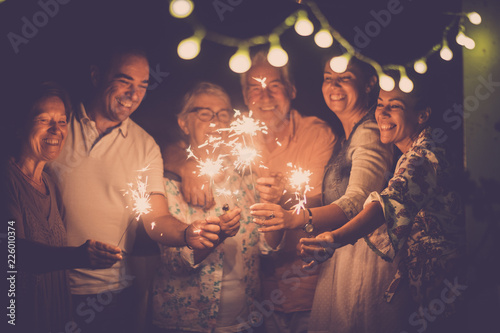Photo group of caucasian people friends with different ages celebrate together a birthday or new year eve by night outdoor at home