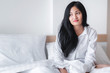 © totojang1977 - Beautiful young pretty Asian woman wake up and make happy smile with white shirt at the white bed in the morning
