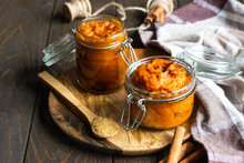 Pumpkin Butter In Glass Jar With Cinnamon Sticks And Sugar On Old Wood Background, Selective Focus.
