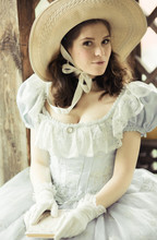 Beautiful Girl In A Hat, Historical Dress, Gloves, With A Book In Her Hands Sitting In The Gazebo