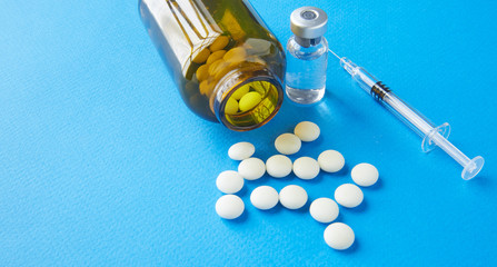 Canvas Print - Brown glass bottle with white pills and a syringe with a pharmaceutical preparation on the table