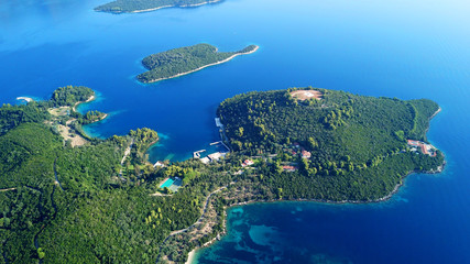 Aerial drone bird's eye view panoramic photo of iconic island of Skorpios that was owned by Aristotle Onasis and port of Nidri at the background, Lefkada island, Ionian, Greece