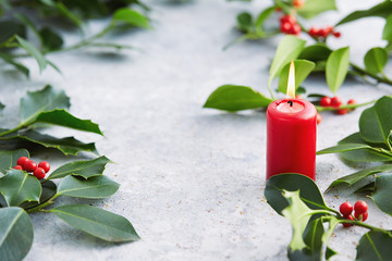 Wall Mural - christmas decorations, candle and holly leaves with red berries.