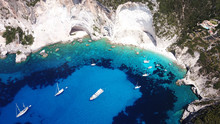 Aerial Drone Bird's Eye View Photo Of Tropical White Rocky Bay Of Erimitis With Turquoise Clear Waters And Sail Boats Docked, Island Of Paxos, Ionian, Greece