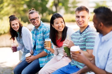 Wall Mural - people, friendship and international concept - group of happy friends drinking coffee and juice talking in city