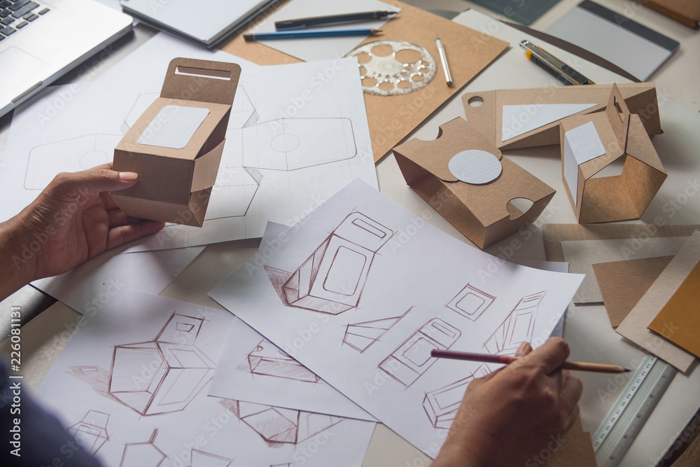 Designer sketching drawing design Brown craft cardboard paper product eco packaging mockup box development template package branding Label . designer studio concept . - obrazy, fototapety, plakaty 