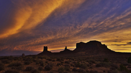 Wall Mural - Silhouettes of buttes and mesas on a multicolor sky as background