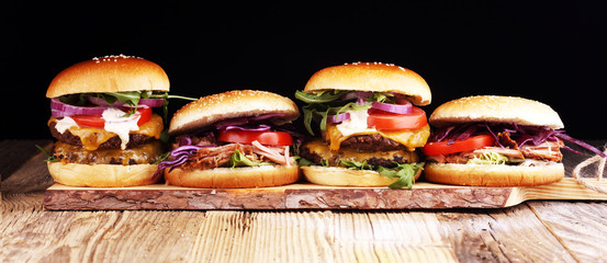 Tasty fresh meat burgers with salad and cheese. Homemade angus burger and Pulled pork sandwiches.