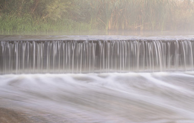 Wall Mural - Mornig fog over a river diversion dam