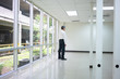 © Paul - Businessman standing in empty bright office and look at wall thinking