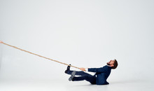 Business Man Pulls The Rope On An Isolated White Background