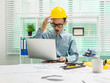 © Phushutter - Young Asian man architect working at working desk about his housing project.