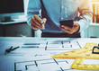 © Phushutter - Young Asian man architect working at working desk about his housing project.