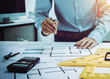 © Phushutter - Young Asian man architect working at working desk about his housing project.