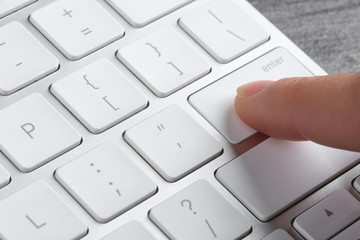 Woman pressing button on computer keyboard, closeup