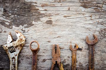 Old rusty tools on wooden background. vintage styles