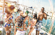 Multiracial Friends Group Having Fun Drinking Wine At Sail Boat Party - Friendship Concept With Young Multi Racial People On Sailboat - Happy Travel Lifestyle On Luxury Location - Warm Bright Filter