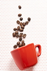 red cup fallen with coffee beans spilled out like espresso moka coffee graphic concept 