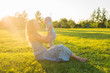 © satura_ - Young woman with boy on the meadow on a sunny day. Happy family on summer sunset. Mother with baby.