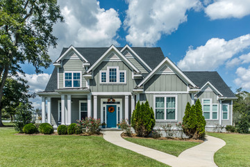 gray new construction modern cottage home with hardy board siding and teal door with curb appeal