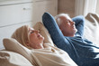 © fizkes - Calm senior mature couple relaxing on soft comfortable sofa having daytime nap together, carefree middle aged old family breathing fresh air enjoying no stress free peaceful weekend resting on couch