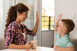 © Goran - Happy little boy giving high-five to his mother