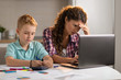 © Goran - Mother working on laptop while being with her son at home