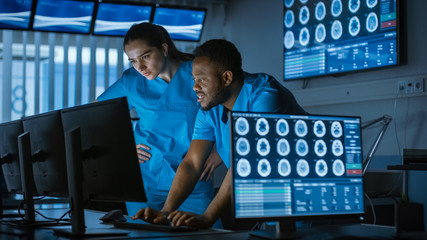 Male and Female Scientists / Neurologists, Talking and  Working on a Personal Computer in Modern Laboratory. Research Medical Scientists Making New Discoveries in the fields of Science