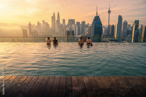 Traveler looking view skyline Kuala Lumpur city in swimming pool on the roof top of hotel at sunrise in Kuala Lumpur, Malaysia Canvas Print